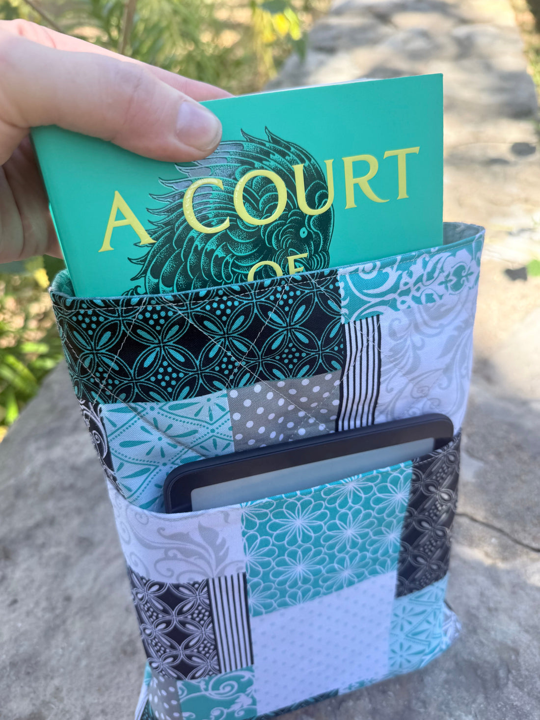 Handmade quilted book sleeve with a book and Kindle, from the EnTyre Creations holiday gift guide