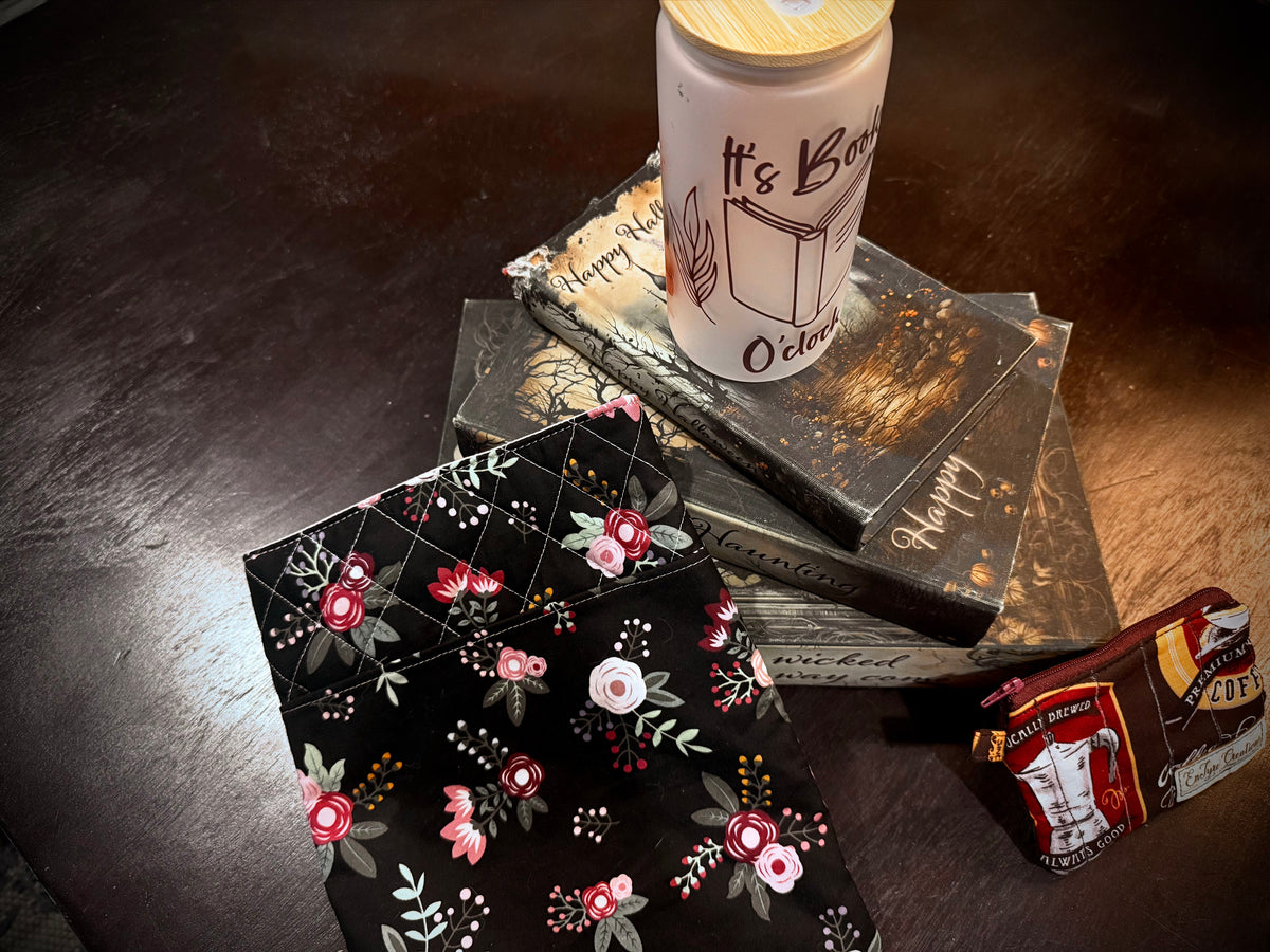 Handmade quilted book sleeves in black rose fabric with a bookish glass can and books, from EnTyre Creations